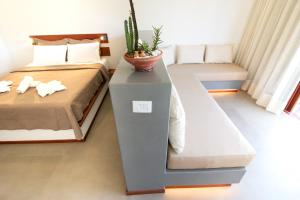 圣米格尔-杜戈斯托苏Portofino Pousada的一间卧室,配有一张床和一张桌子上的植物