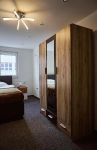 上科亨Boardinghouse Apart-Hotel的一间卧室配有带镜子的大型木制橱柜