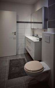 上科亨Boardinghouse Apart-Hotel的白色的浴室设有卫生间和水槽。