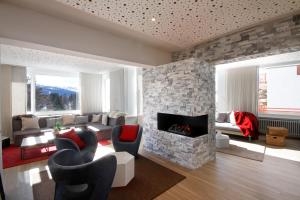 克莱恩 蒙塔纳艾莱特酒店的客厅设有石制壁炉和椅子