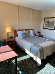 克拉马斯福尔斯Townhouse Inn & Suites的酒店客房设有一张大床和两张桌子。