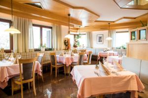 纳兹-夏韦斯Hotel Föhrenhof的餐厅配有桌椅和粉红色的桌布