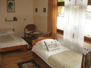 扎科帕内德瓦伊迪斯别墅酒店的一间卧室设有两张床、一个窗口和椅子
