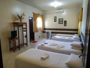 圣塔伦hotel encontro das aguas的酒店客房设有三张床和电视。
