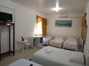 圣塔伦hotel encontro das aguas的客房设有三张床和一台平面电视。
