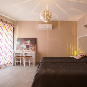 圣伊波利特迪福尔Logis Auberge Cigaloise的一间卧室配有一张床铺和一张桌子,还有一间用餐室