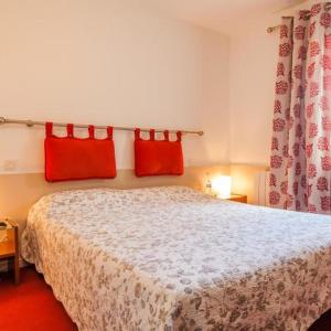 圣伊波利特迪福尔Logis Auberge Cigaloise的一间卧室配有一张带红色枕头的床