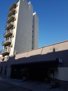 布宜诺斯艾利斯Dallas Hotel -Motel-的一座高大的建筑,前面有一个车库