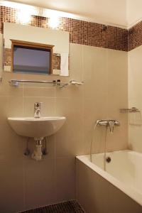 塞萨洛尼基佩拉酒店的浴室配有盥洗盆和浴缸。