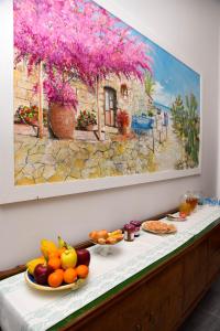 兰佩杜萨DolceLina Home的一张桌子,上面有水果,墙上有画