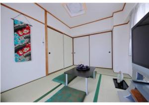 大阪Daihan Building / Vacation STAY 3309的客厅配有桌子和电视