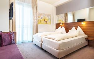 格拉茨Hotel Römerstube的卧室配有一张白色大床和木制床头板