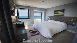 马德普拉塔Hotel AATRAC的一间卧室配有一张床,享有海景