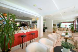 里乔内Hotel De Amicis的一间设有白色椅子和酒吧的等候室