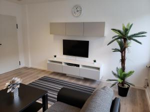 明斯特Ferienwohnung Central的一间客厅,在白色的墙上配有电视