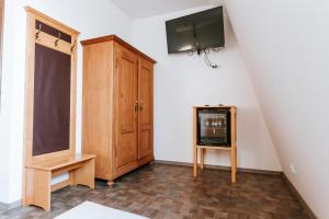CoşeniConacul Nagy的客房设有电视和木制橱柜。
