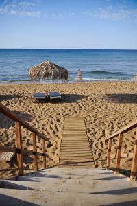 斯塔罗斯The Mini Beach Hotel的一个带木板路和遮阳伞的海滩