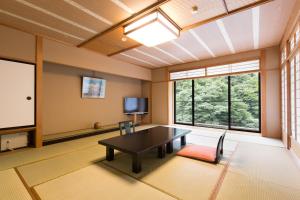 朝日小川日式旅馆的大型客房配有桌子和电视。