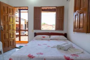 伊尔哈德博伊巴Pousada & Kitnet Nascer do Sol的一间卧室配有带2条毛巾和2个窗户的床