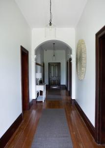 马奇The Bower Mudgee的一条带白色墙壁和木地板的走廊和一扇门