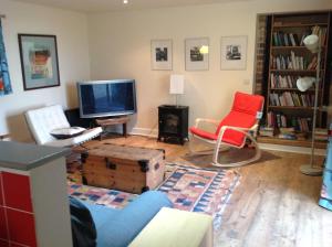 Kirkton of LargoCutty Sark Cottage的客厅配有电视和2把椅子