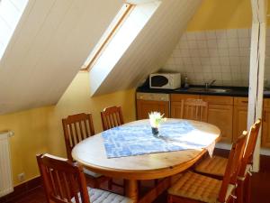 克吕茨Ostsee-Ferienoase-3-Raum-App-Typ-1的厨房配有木桌、椅子和窗户