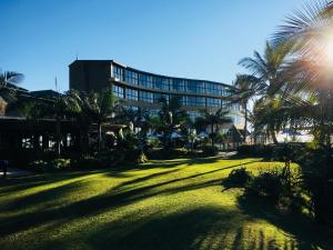 巴利托Salt Rock Hotel and Beach Resort的一座大草坪,在一座建筑前有棕榈树