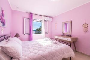 尼萨基奥Alkinoi Seaview Villa with Private Pool by Konnect, Nisaki的粉红色的卧室设有床和窗户
