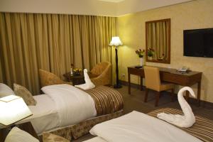 安曼Saray Hotel Amman的酒店客房带两张床,还有天鹅