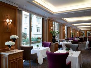 雅典NJV雅典广场酒店的餐厅设有白色的桌椅和窗户。