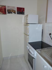 巴黎33 Villa Curial的厨房配有白色炉灶和冰箱。