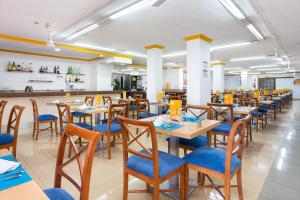 拉克鲁斯水族全球酒店的餐厅设有木桌和蓝色椅子