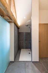 Autre-ÉgliseKoru Hôtel & Private Wellness的一间位于客房角落的带淋浴的浴室