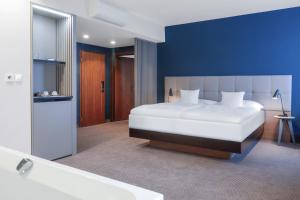 胡门内卡尔帕提亚酒店的卧室配有一张白色大床和浴缸