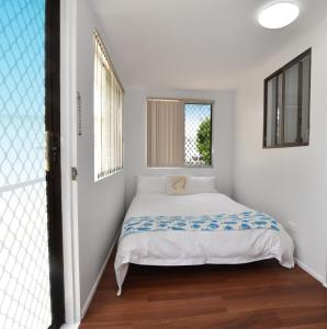 布里斯班Holiday House的一间小卧室,配有床和窗户