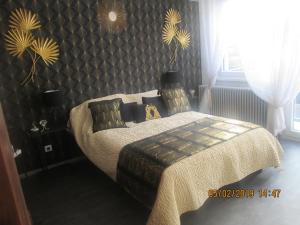 利戈尔塞姆Gîte du Coq的一间卧室配有一张带毯子和墙壁的床