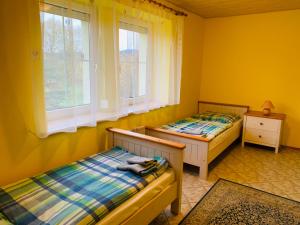 霍尼普拉纳罗扎利尔公寓酒店的配有两张床铺的黄色墙壁和窗户