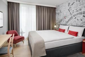 美因河畔法兰克福IntercityHotel Frankfurt Hauptbahnhof Süd的酒店客房,配有一张床和一张红色椅子