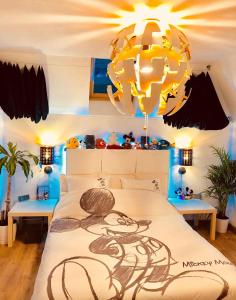 马尼库尔勒翁格尔Chambres d'hôtes à thèmes à 2,4Km du parc的一间卧室配有一张大床和一个吊灯。