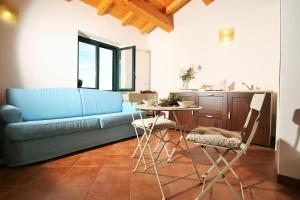 米罗Agriturismo Le Case Del Merlo的客厅配有蓝色的沙发和桌子