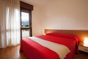 托尔博莱Casa Lucia的一间卧室设有红色的床和窗户。