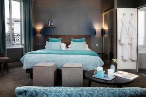 巴黎Hôtel Plaza Étoile的酒店客房配有一张床铺和一张桌子。