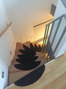 TönisvorstApartment mit Parkblick的黑色地毯房子中的螺旋楼梯