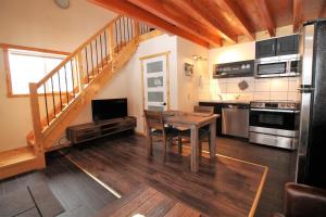 Anahim LakeRed Cariboo Apartments的厨房设有餐桌和楼梯。