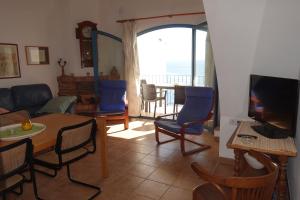 卡莱利亚德帕拉弗鲁赫尔Duplex in front of the sea in Calella de Palafrugell -130的客厅配有电视和桌椅