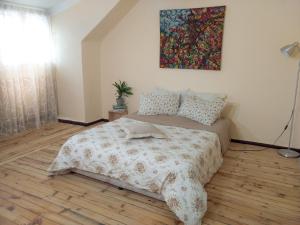 索非亚Good Stay Sofia Apartments的卧室配有一张床,墙上挂有绘画作品