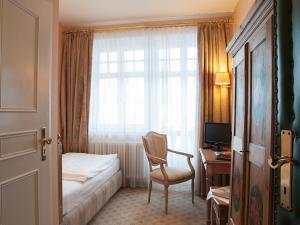 泰根塞Gästehaus Florian的酒店的客房 - 带一张床、椅子和窗户