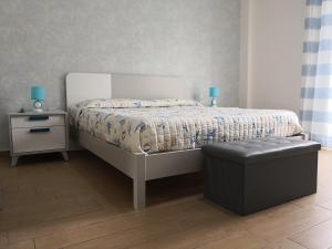 塔兰托Corso Italia 83的一间卧室配有一张带搁脚凳和一张桌子的床