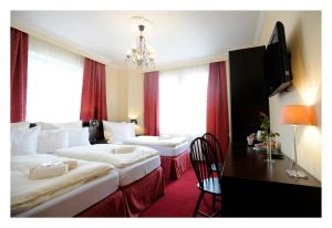 利贝雷茨Pytloun Design Self Check-in Hotel的酒店客房设有两张床、一张桌子和一台电视。