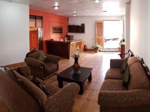 马塔加尔帕Hostal Casa Vieja的客厅配有两张沙发和一张桌子
